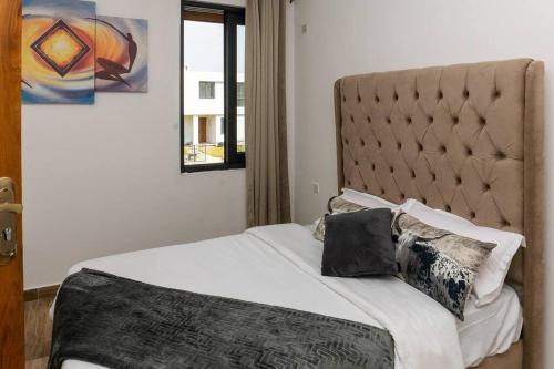 卢萨卡Urban oasis in kingsland city的一间卧室配有一张带床头板和枕头的床