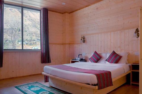 拉冲Keerong Cottages Lachung的木制客房内的一间卧室,配有一张床