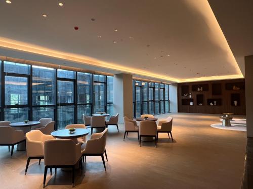 台州台州开投华美达酒店的餐厅设有桌椅和窗户。