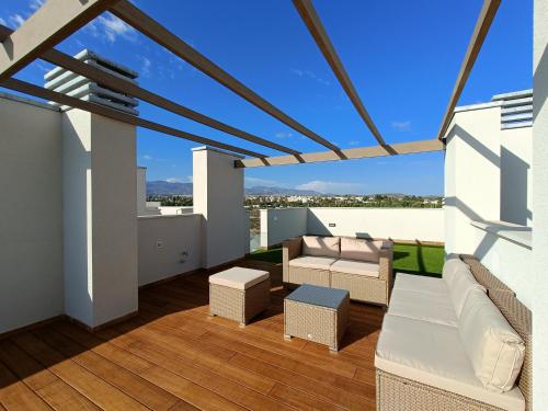 El ToyoNuevo Ático Toyo. Vistas al mar, terraza, solarium, piscina, A/A, WiFi y Garaje的设有一个配有白色家具的阳台,享有美景。