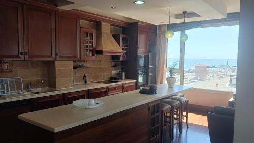 拉纳卡Quattro Sea View Beachfront Ap 6的一个带柜台和大窗户的厨房