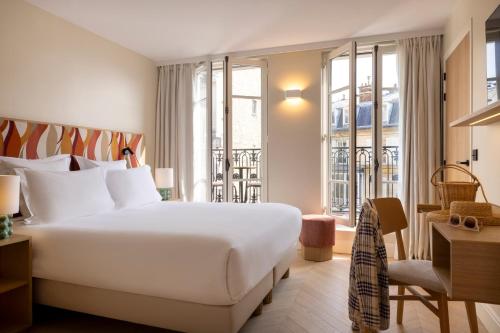 巴黎Padam Hôtel的酒店客房设有一张大床和窗户。