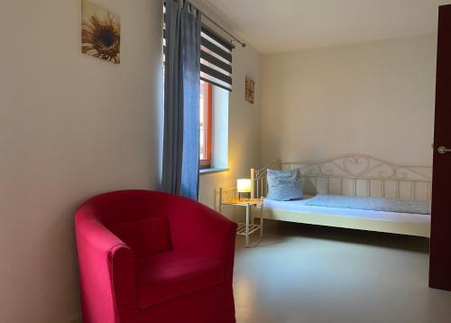 奎德林堡天堂&地狱自助式公寓酒店的一间卧室配有红色椅子和一张床