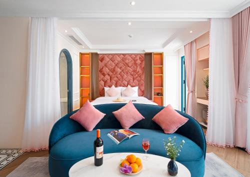 芽庄Pavillon Boutique Hotel & Apartment Nha Trang的酒店客房,配有床和蓝色的沙发