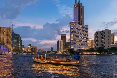 曼谷曼谷千禧希爾頓酒店 的河上船,城市背景