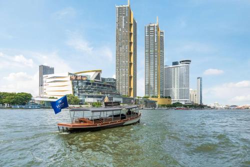 曼谷曼谷千禧希爾頓酒店 的城市前的水中小船