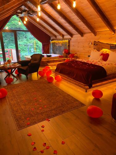 贾马里海姆森Hoşdere Suit的卧室配有一张床,地板上摆放着红色鲜花