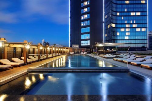 伊斯坦布尔伊斯坦布尔波蒙第希尔顿酒店的夜间在建筑物屋顶上的游泳池