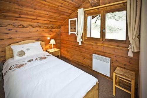 莱斯奥琉斯Meribel Les Allues Ski Chalet with beautiful views的小木屋内一间卧室,配有一张床