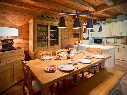 莱斯奥琉斯Meribel Les Allues Ski Chalet with beautiful views的厨房里设有1间带木桌的用餐室