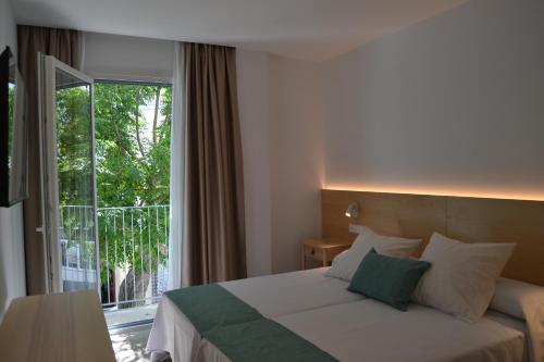 科尼尔-德拉弗龙特拉绿洲酒店的一间卧室设有一张床和一个大窗户