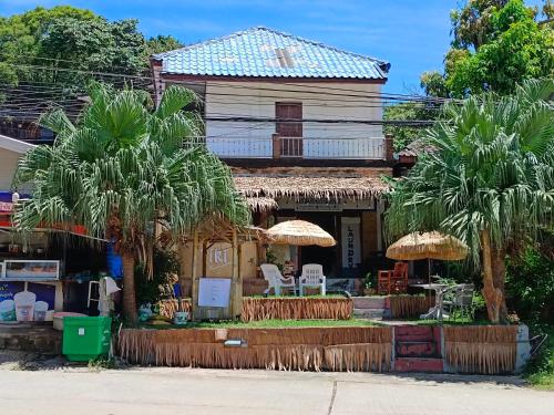 高兰Tiki Bar-KanTiang Guesthouse的前面有棕榈树的房子