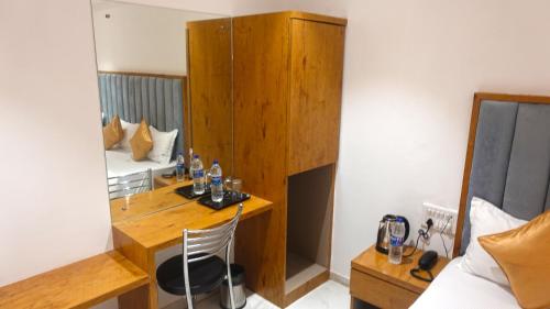 孟买Hotel Palms Residency, Chembur Mumbai的客房设有书桌、床和镜子