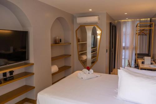皮帕Exótica Boutique Hotel的卧室配有白色的床和镜子