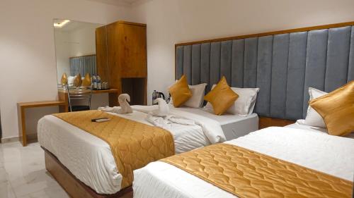 孟买Hotel Palms Residency, Chembur Mumbai的酒店客房,配有两张带毛巾的床