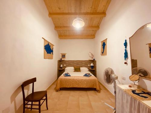 卡洛福泰Guest House Calalunga Scogliera的一间卧室,卧室内配有一张床和一把椅子
