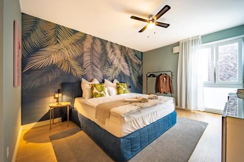 巴德茨维什安LUXX APARTMENTS I Luxx Central I Design I Komfort的一间卧室设有一张带绿叶墙的大床