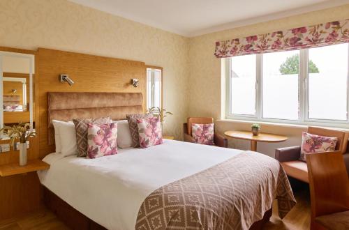 沃尔索尔菲尔劳温斯温泉酒店的一间卧室设有一张大床和两个窗户。