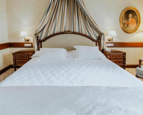 塞哥维亚坎迪多酒店的一间卧室配有一张带2个床头柜的大型白色床