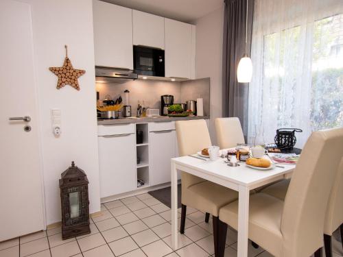 诺德代希Apartment Muschelweg-2 by Interhome的厨房配有白色的桌椅