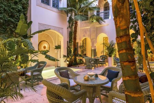 马拉喀什里亚德伊德拉酒店的庭院内带桌椅的庭院。