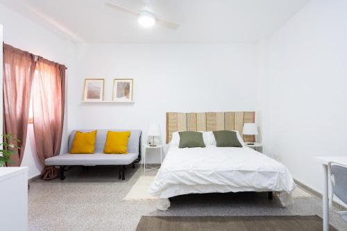 格拉纳迪利亚德亚沃纳EDEN RENTALS B01 Surfy Stylish Bed&Coffee Room的白色卧室配有床和沙发