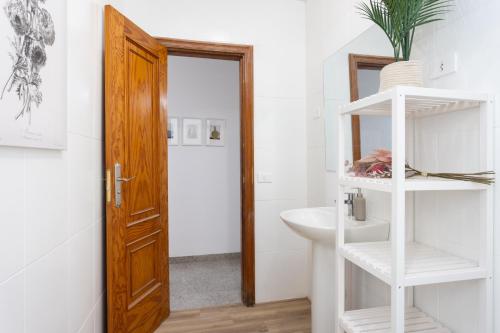 格拉纳迪利亚德亚沃纳EDEN RENTALS B01 Surfy Stylish Bed&Coffee Room的一间带白色水槽和木门的浴室