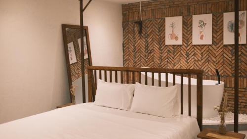 绥和市Vũ House Phú Yên- Boutique Room & Breakfast的一张带木制床头板和白色枕头的床