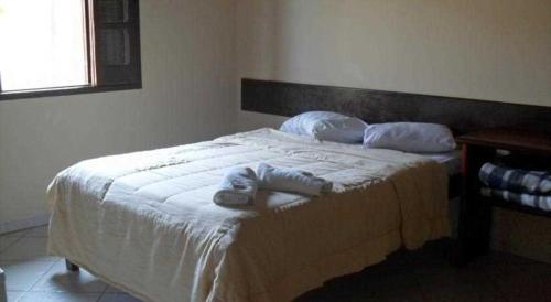沙帕达-杜斯吉马朗伊斯POUSADA PEQUIZEIRO的一间卧室配有一张床,上面有两条毛巾