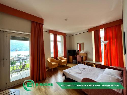 洛迦诺E-Rooms Minusio的酒店客房设有一张床和一个阳台。
