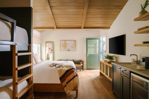拉古纳海滩Sonder Woods Cove的一间卧室配有一张床和一张书桌及电视