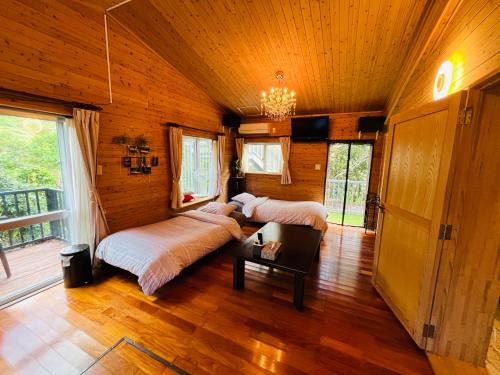 UjimiLodge Crea的配有木墙和木地板的客房中的两张床
