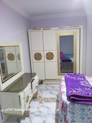 Al Ḩamīdātالاسكندريه的一间卧室配有一张床、梳妆台和镜子