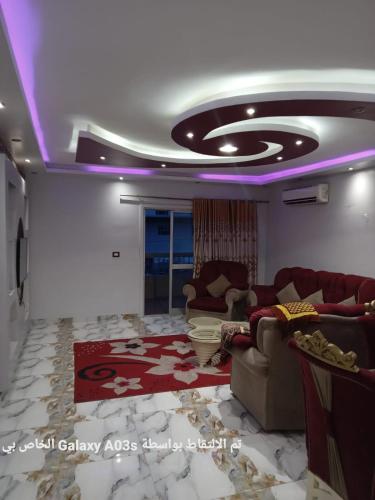 Al Ḩamīdātالاسكندريه的带沙发的客厅和带紫色灯的天花板