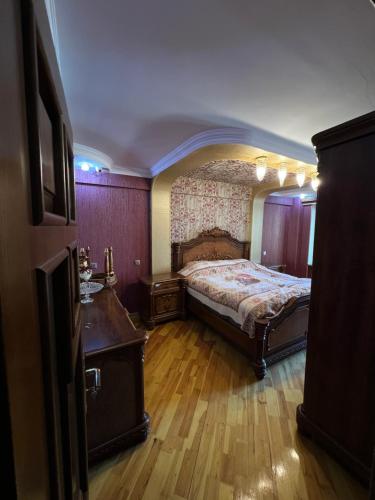 巴库Genclik的一间卧室配有一张床,铺有木地板