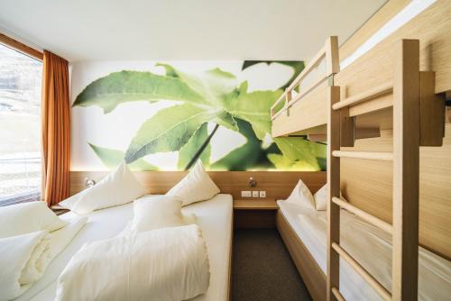 萨姆瑙恩斯玛特酒店的卧室配有两张床,墙上挂着植物