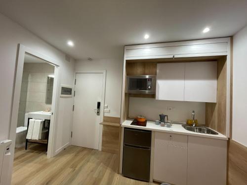 普拉德埃米塔Apartamentos La Solana的厨房配有白色橱柜和水槽