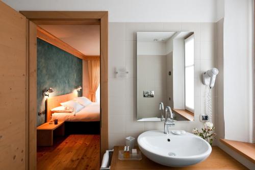 博尔米奥穆布雷赛托雷丽里特酒店的一间带水槽的浴室和一间带一张床的卧室