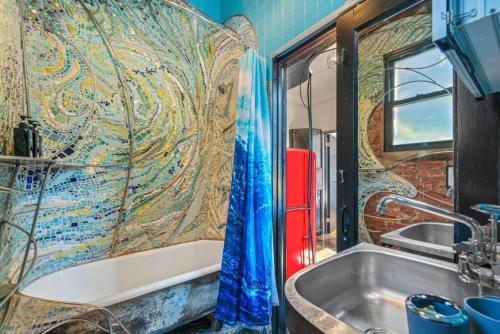布鲁克林Artistic Loft A Century-Old Gem的带浴缸和马赛克墙的浴室。