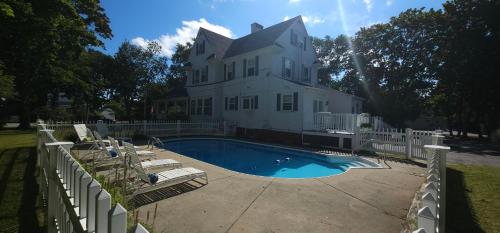 旧奥查德比奇Old Orchard Beach Inn的一座白色的房子,前面设有一个游泳池