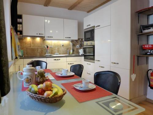 伯尼根Apartment Tilia by Interhome的厨房配有一张桌子,上面有一篮水果