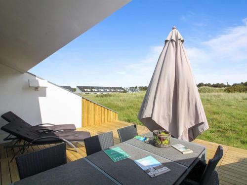 布洛克胡斯Apartment Virpi - 1km from the sea in NW Jutland by Interhome的一个带桌子和遮阳伞的庭院