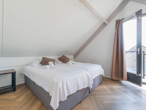 EwijkHoliday Home Forest Cottage Ewijk incl- hot tub by Interhome的一间卧室配有一张带白色床单的床和一扇窗户。