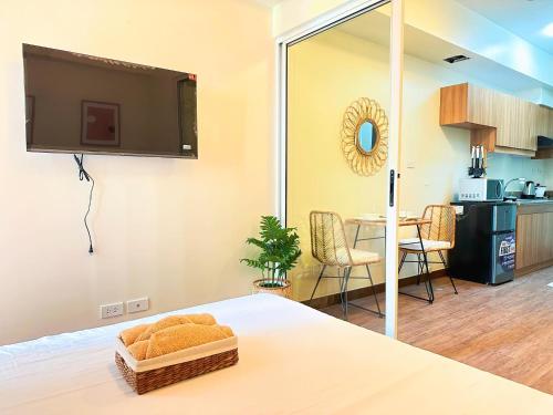 马尼拉1BR Prisma Residences DMCI Stylish Condo的一间设有一张床铺的房间,墙上配有电视