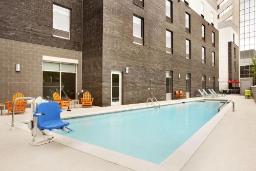 格林维尔格林维尔市中心希尔顿欣庭套房酒店的一个带蓝色椅子和椅子的大型游泳池