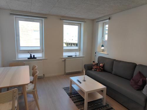 奥尔堡奥尔堡市客房公寓的客厅配有沙发和桌子