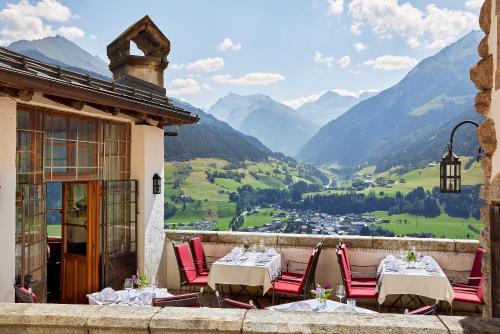 米特西尔Hotel Schloss Mittersill的阳台配有桌椅,享有山景。