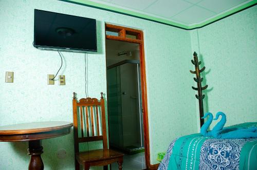 乌尤尼HOSTAL SALARCITO的卧室配有一张床,墙上配有电视