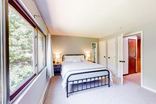 ThorntonMad River Mountain Getaway的一间卧室设有一张床和大窗户