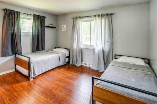 罗切斯特Enjoyable Home by Airport & Dwtn的一间卧室设有两张床,铺有木地板